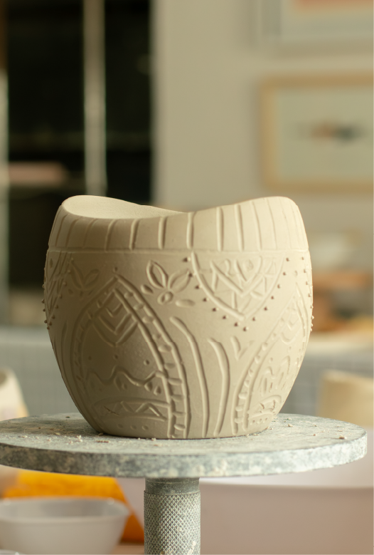 Pieza de cer&aacute;mica en bizcocho sobre la mesa de trabajo, lista para decorar en el taller Fuera de Serie
